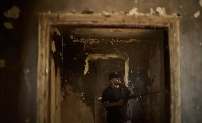 A Palestinian man cleans a room of a house damaged following an attack by Israeli settlers the previous day in the village of Sarra, near the West Bank city of Nablus, Saturday, July 25, 2026. (AP Photo/Leo Correa)