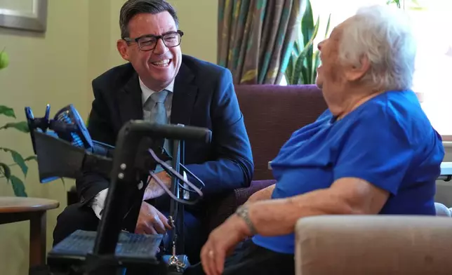 Britain's Prime Minister Andy Burnham talks to a resident during a visit to a care home in London, Wednesday, July 29, 2026.(AP Photo/Kirsty Wigglesworth, Pool)