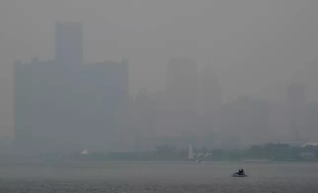 A watercraft sits in the Detroit River near the skyline during poor air quality due to smoke from Canadian wildfires Thursday, July 16, 2026, in Detroit. (AP Photo/Paul Sancya)