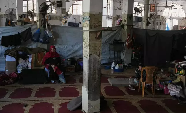 Palestinian women sit in the hall of Bilal Mosque, which has been converted into a shelter for displaced people, in Khan Younis, southern Gaza Strip, Friday, July 10, 2026. (AP Photo/Abdel Kareem Hana)