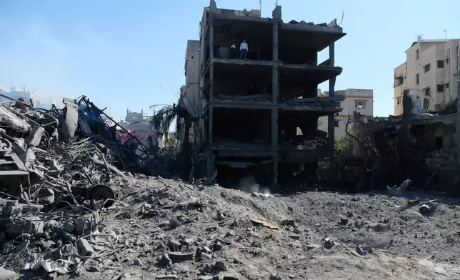 Palestinians gather around a blacksmith shop in Gaza City's Sabra neighborhood after it was hit by an Israeli military strike on Sunday, July 12, 2026. (AP Photo/Jehad Alshrafi)