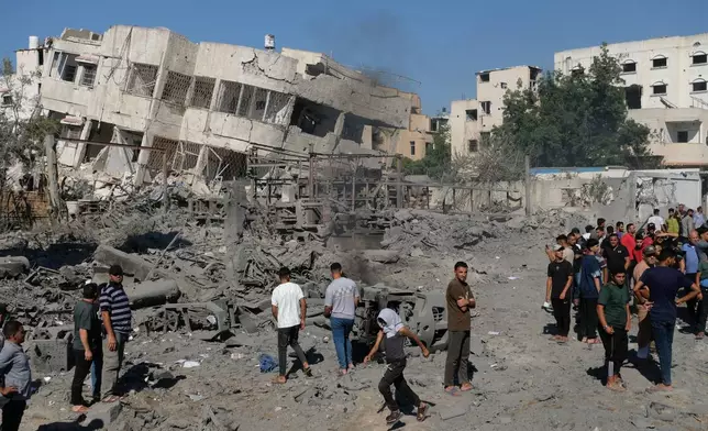 Palestinians gather around the site of an Israeli military drone strike on a blacksmith shop in Gaza City's Sabra neighborhood killing at least four Palestinians and wounded another, according to officials at Shifa hospital, where the casualties were taken on Sunday, July 12, 2026. (AP Photo/Jehad Alshrafi)