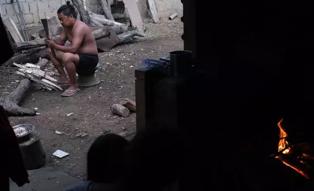 Tovi Murru, 32, chops wood to cook dinner in Kohima, capital of the northeastern Indian state of Nagaland, Monday, July 6, 2026. (AP Photo/Yirmiyan Arthur)