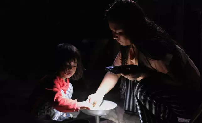 Atoshi Ayemi eats dinner with her daughter Azatina Murru inside their kitchen in Kohima, capital of the northeastern Indian state of Nagaland, Monday, July 6, 2026. (AP Photo/Yirmiyan Arthur)