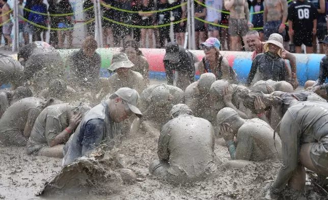 People play in a mud pool during the Boryeong Mud Festival near a beach in Boryeong, South Korea, Saturday, July 25, 2026. (AP Photo/Lee Jin-man)