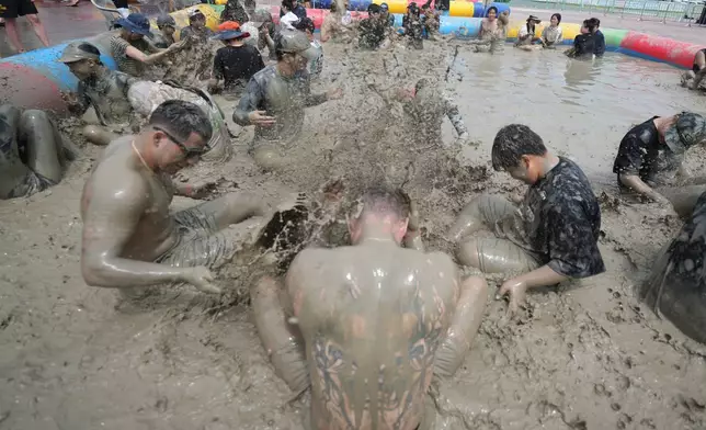 People play in a mud pool during the Boryeong Mud Festival near a beach in Boryeong, South Korea, Saturday, July 25, 2026. (AP Photo/Lee Jin-man)