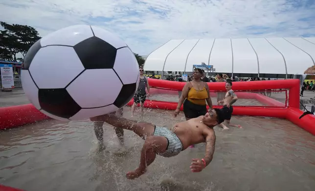 Chito Baro of the U.S. plays with a ball during the Boryeong Mud Festival near a beach in Boryeong, South Korea, Saturday, July 25, 2026. (AP Photo/Lee Jin-man)