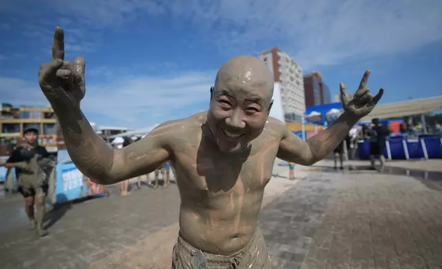 South Korean Ryan Kang, covered in mud, poses for a photo during the Boryeong Mud Festival near a beach in Boryeong, South Korea, Saturday, July 25, 2026. (AP Photo/Lee Jin-man)