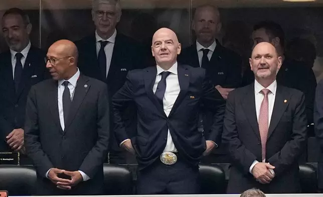 FIFA President Gianni Infantino, center, wearing a Texas belt buckle, adjusts his pants during the World Cup semifinal soccer match between France and Spain in Arlington, Texas, near Dallas, Tuesday, July 14, 2026. (AP Photo/Ashley Landis)