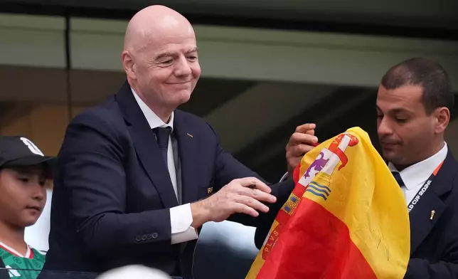 FIFA president Gianni Infantino signs autographs after Spain defeated France the World Cup semifinal soccer match in Arlington, Texas, near Dallas, Tuesday, July 14, 2026. (AP Photo/Eric Gay)