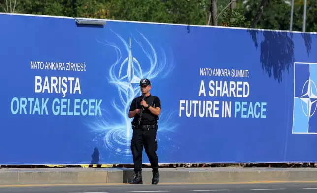 Police patrol in front of a banner ahead of the NATO Summit in Ankara, Turkey, Sunday, July 5, 2026. (AP Photo/Riza Ozel)