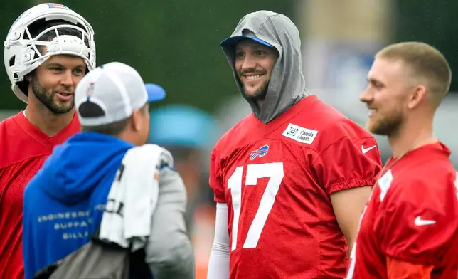 Buffalo Bills quarterback Josh Allen, center, talks with quarterbacks Kyle Allen, left, and Shane Buechele, right, before practice at the team's NFL football training camp Wednesday, July 29, 2026, in Pittsford, N.Y. (AP Photo/Adrian Kraus)