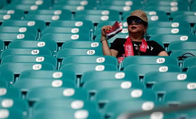 A spectator fan herself before the World Cup quarterfinal soccer match between Norway and England in Miami Gardens, Fla., Saturday, July 11, 2026. (AP Photo/George Walker IV)