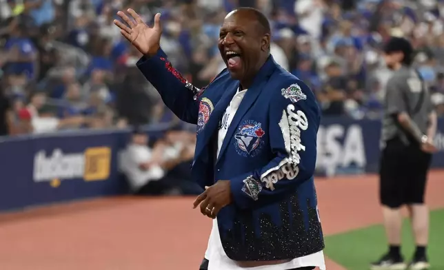 Toronto Blue Jays alumni Joe Carter waves to the crowd while taking part in the 1992-1993 commemoration and statue unveiling prior to the Jays taking on the Chicago White Sox in a baseball game in Toronto, Saturday, July 18, 2026. (Jon Blacker/The Canadian Press via AP)