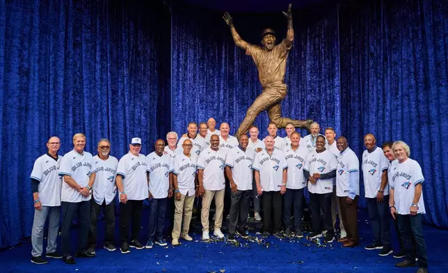 Toronto Blue Jays' Joe Carter, centre, is joined by members of the 1992 and 1993 Blue Jays at the unveiling of a statue commemorating the Toronto Blue Jays' 1992 and 1993 World Series wins ahead of a baseball game against the Chicago White Sox in Toronto, Saturday, July 18, 2026. (Sammy Kogan/The Canadian Press via AP)
