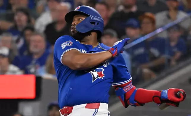 Toronto Blue Jays' Vladimir Guerrero Jr. (27) hits a single against the Chicago White Sox during first inning of a baseball game in Toronto, Saturday, July 18, 2026. (Jon Blacker/The Canadian Press via AP)