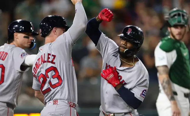 Boston Red Sox's Andruw Monasterio, right, celebrates with teammate Romy Gonzalez (23) after hitting a two-run home run during the 10th inning of a baseball game against the Athletics Wednesday, July 29, 2026, in West Sacramento, Calif. (AP Photo/Scott Marshall)