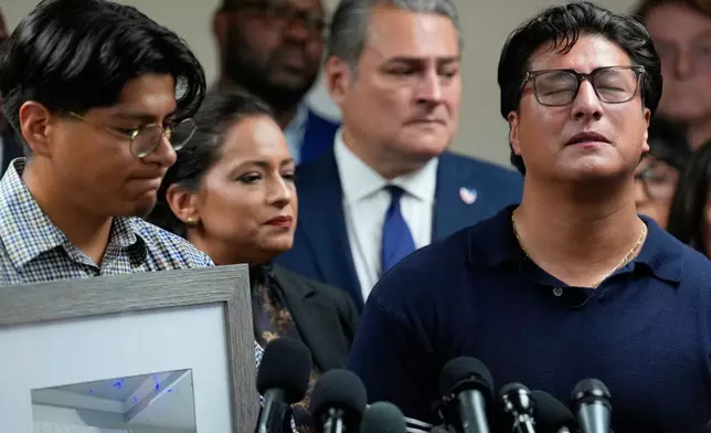 Ronaldo Salgado, son of Lorenzo Salgado Araujo, speaks as his brother, Lorenzo Jr., left, holds family photographs during a news conference Wednesday, July 8, 2026, in Houston. (AP Photo/David J. Phillip)