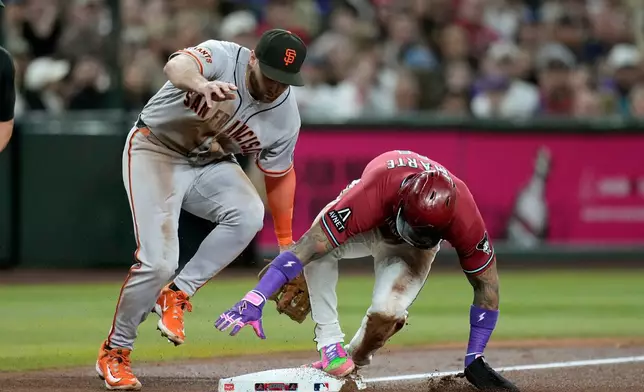 Arizona Diamondbacks' Ketel Marte, right, steals third base as San Francisco Giants third baseman Casey Schmitt, left, applies a late tag during the fourth inning of a baseball game, Wednesday, July 1, 2026, in Phoenix. (AP Photo/Ross D. Franklin)