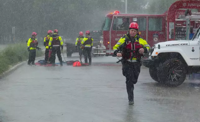 Members of the Boerne Fire Dept. prepare to perform a water rescue on Wednesday, July 15, 2026, in Boerne, Texas. (AP Photo/Darren Abate)