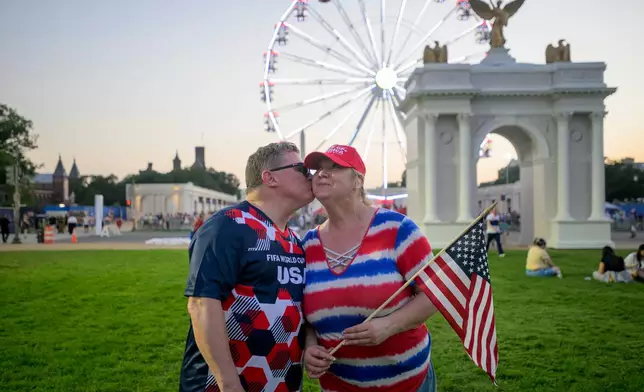 Todd Shaw, left, kisses his wife Shannon Shaw, right, as they pose for portrait during the Great American State Fair on the National Mall, Thursday, July 2, 2026, in Washington. (AP Photo/Rod Lamkey, Jr.)