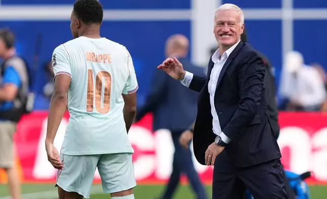 France head coach Didier Deschamps smiles after hugging France's Kylian Mbappe (10) after France defeated Morocco in the World Cup quarterfinal soccer match between France and Morocco in Foxborough, Mass., near Boston, Thursday, July 9, 2026. (AP Photo/Martin Meissner)
