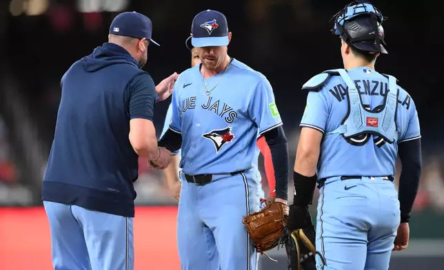 Toronto Blue Jays starting pitcher Shane Bieber, center, is pulled by manager John Schneider, left, during the first inning of a baseball game against the Washington Nationals, Tuesday, July 28, 2026, in Washington. (AP Photo/Nick Wass)