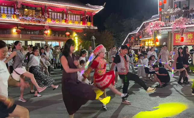 Strangers to one another, visitors still join hands and dance under the night sky. Photo by Bastille Post