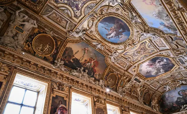 A visitor looks on during the reopening to the public of the Apollo Gallery, at the Louvre museum in Paris, Wednesday, July 22, 2026. (Lou Benoist/Pool Photo via AP)