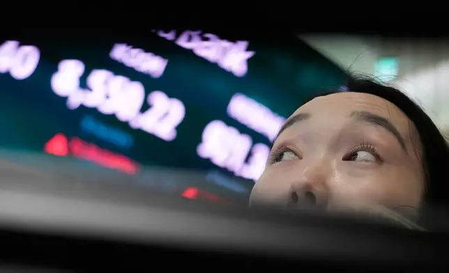 A currency trader watches monitors near a screen showing the Korea Composite Stock Price Index (KOSPI) at the foreign exchange dealing room of the Hana Bank headquarters in Seoul, South Korea, Wednesday, July 1, 2026. (AP Photo/Ahn Young-joon)