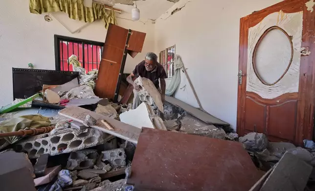 Mohammed Sobeih clears debris inside his home after returning to it following the Israeli military operation in Zawtar al-Gharbieh, Lebanon, Tuesday, July 28, 2026. (AP Photo/Hassan Ammar)