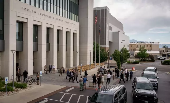 Journalists gather around as Charlie Kirk's parents exit with security guards after a preliminary hearing for Tyler Robinson, who is accused in the fatal shooting of Charlie Kirk, at the Fourth District Courthouse in Provo, Utah, Thursday, July 9, 2026. (AP Photo/Spenser Heaps)
