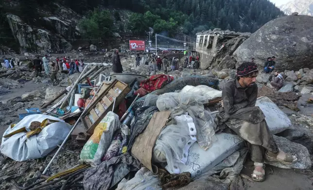 A man sits beside salvaged belongings following heavy flooding in the eastern province of Nuristan, Afghanistan, Tuesday, July 21, 2026. (AP Photo/Wahidullah Kakar)