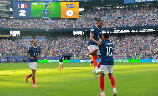France's Kylian Mbappe (10) celebrates scoring their third goal with Michael Olise (11) during the World Cup round of 32 soccer match between France and Sweden in East Rutherford, N.J., near New York, Tuesday, June 30, 2026. (AP Photo/Pamela Smith)