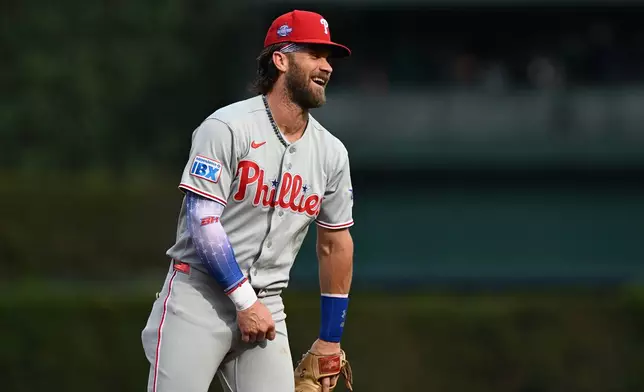Philadelphia Phillies' Bryce Harper laughs with the first base umpire after tagging out Detroit Tigers' Matt Vierling on a pickoff play in the first inning of a baseball game, Saturday, July 11, 2026, in Detroit. (AP Photo/Lon Horwedel)