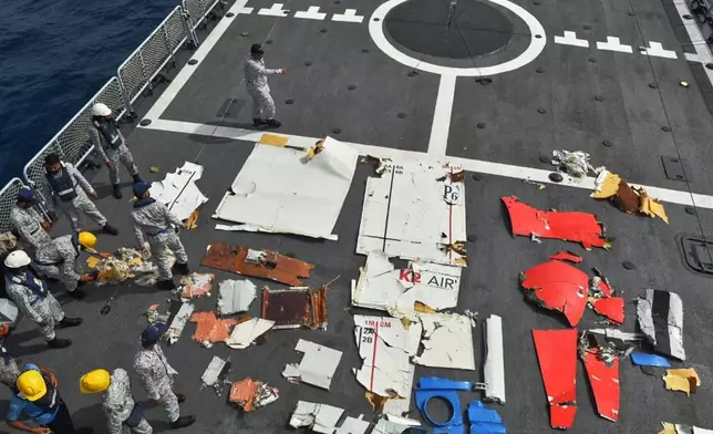 In this photo released by Pakistan Navy, Pakistan Navy personnel examine the wreckage of a cargo plane of the private carrier K2 Airways on a naval ship after recovering them from deep sea near Omara, a town some 360 kms. (220 miles) west of Karachi, Pakistan, Wednesday, July 8, 2026. (Pakistan Navy via AP)