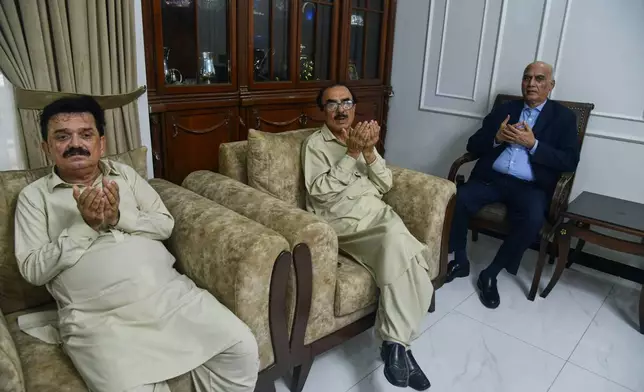 Ghulam Nabi Bahrani, left, father-in-law of missing cargo plane crew First Officer Faisal Jatoi, with others pray for Jatoi at his home in Karachi, Pakistan, Wednesday, July 8, 2026. (AP Photo/Ali Raza)