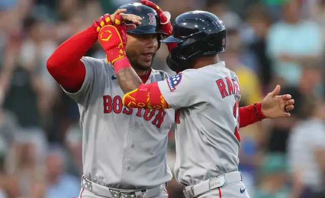 Boston Red Sox's Ceddanne Rafaela, right, celebrates with teammate Willson Contreras, left, after hitting a grand slam during the sixth inning of a baseball game against the Athletics, Monday, July 27, 2026, in West Sacramento, Calif. (AP Photo/Scott Marshall)