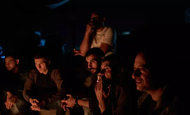 Palestinians sit next to the bonfire as they take part in a night watch to guard against Israeli settler attacks in the West Bank village of Sinjil, Thursday, July 16, 2026. (AP Photo/Leo Correa)