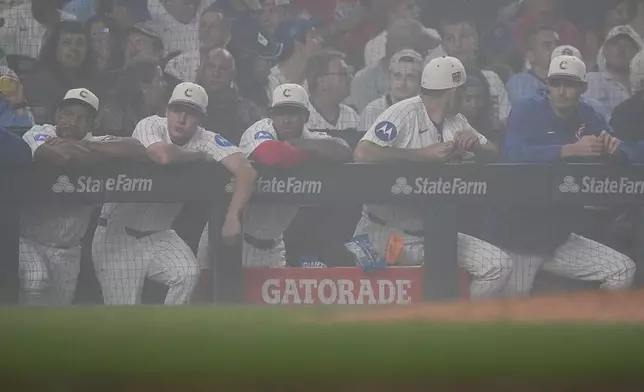 Chicago Cubs stand in the dugout during a fog delay during the sixth inning of a baseball game against the St. Louis Cardinals, Saturday, July 4, 2026, in Chicago. (AP Photo/David Banks)