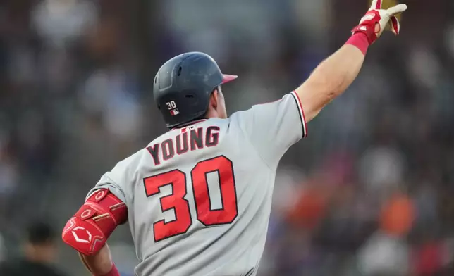 Washington Nationals' Jacob Young gestures to the bullpen as he circles the bases after hitting a solo home run off Colorado Rockies starting pitcher Kyle Freeland in the sixth inning of a baseball game Monday, July 20, 2026, in Denver. (AP Photo/David Zalubowski)