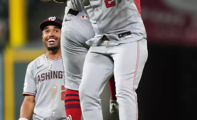 Washington Nationals first baseman Luis GarcÌa Jr., front, celebrates with third baseman Curtis Mead, center, as second baseman Nasim Nuñez, back, looks on after their team defeated the Colorado Rockies in a baseball game Monday, July 20, 2026, in Denver. (AP Photo/David Zalubowski)