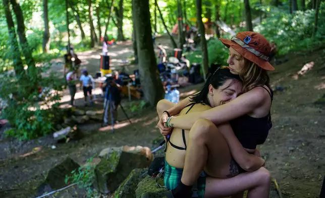 Women rest after climbing during the Stoned Climbers festival near Denyshi, Zhytomyr region, Ukraine, Saturday, June 27, 2026. (AP Photo/Evgeniy Maloletka)
