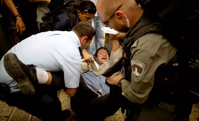 FILE - Israeli right wing activist Itamar Ben-Gvir is detained by police after shouting slogans at White House Chief of Staff Rahm Emanuel, during his visit to Jerusalem's old city Thursday, May 27, 2010. (AP Photo/Sebastian Scheiner, file)