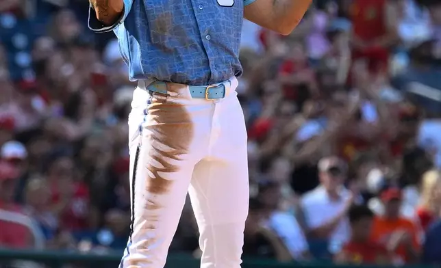 Washington Nationals' Daylen Lile gestures at third base after hitting a triple during the third inning of a baseball game against the Arizona Diamondbacks, Saturday, July 25, 2026, in Washington. (AP Photo/Nick Wass)