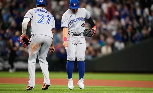 Toronto Blue Jays first baseman Vladimir Guerrero Jr. celebrates with third baseman Kazuma Okamoto, facing, after a win over the Seattle Mariners in a baseball game, Friday, July 3, 2026, in Seattle. (AP Photo/Lindsey Wasson)