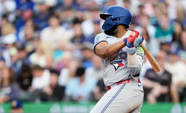 Toronto Blue Jays' Vladimir Guerrero Jr. hits an RBI single to score Andrés Giménez against the Seattle Mariners during the third inning of a baseball game, Friday, July 3, 2026, in Seattle. (AP Photo/Lindsey Wasson)