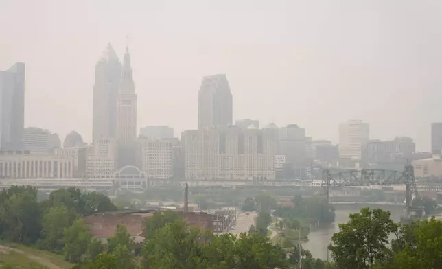 Smoke from Canadian wildfires blankets downtown Cleveland, forcing the postponement of a baseball game between the Pittsburgh Pirates and the Cleveland Guardians in Cleveland, Friday, July 17, 2026. (AP Photo/Sue Ogrocki)