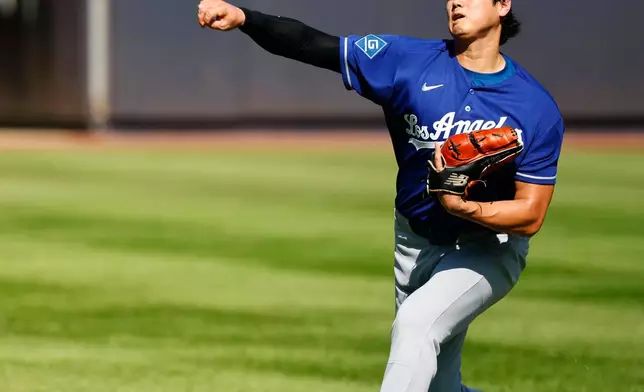 Los Angeles Dodgers' Shohei Ohtani throws in the outfield before the second game of a baseball doubleheader against the New York Yankees, Sunday, July 19, 2026, in New York. (AP Photo/Noah K. Murray)