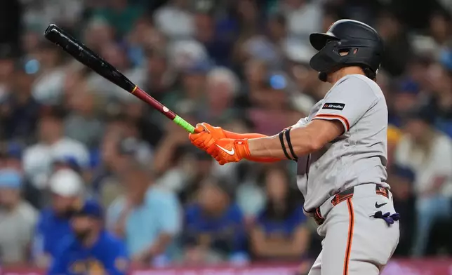 San Francisco Giants' Willy Adames follows through on a grand slam against the Seattle Mariners during the seventh inning of a baseball game, Friday, July 17, 2026, in Seattle. (AP Photo/Lindsey Wasson)